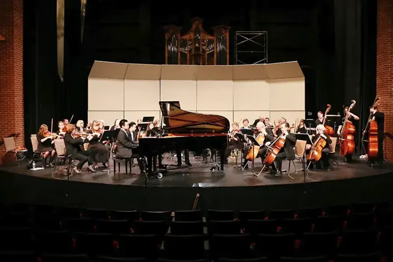 Piano on stage surrounded by orchestra